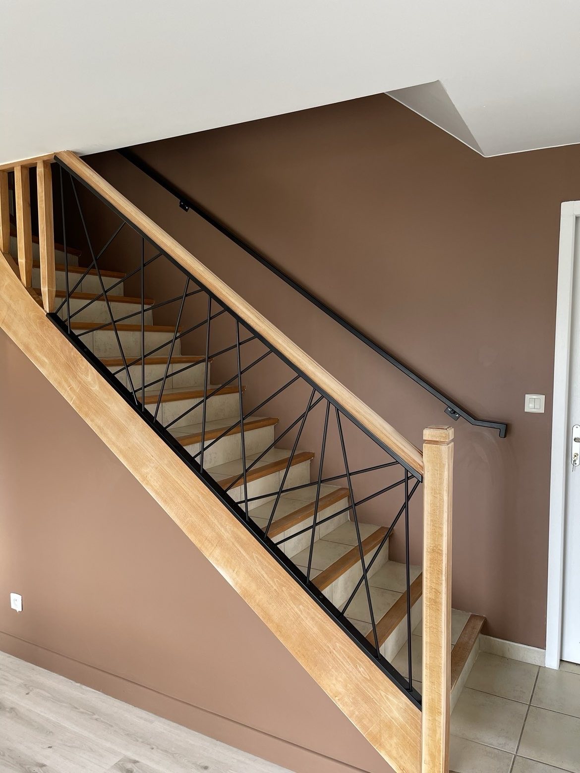 Garde-corps géométrique en acier noir sur escalier bois